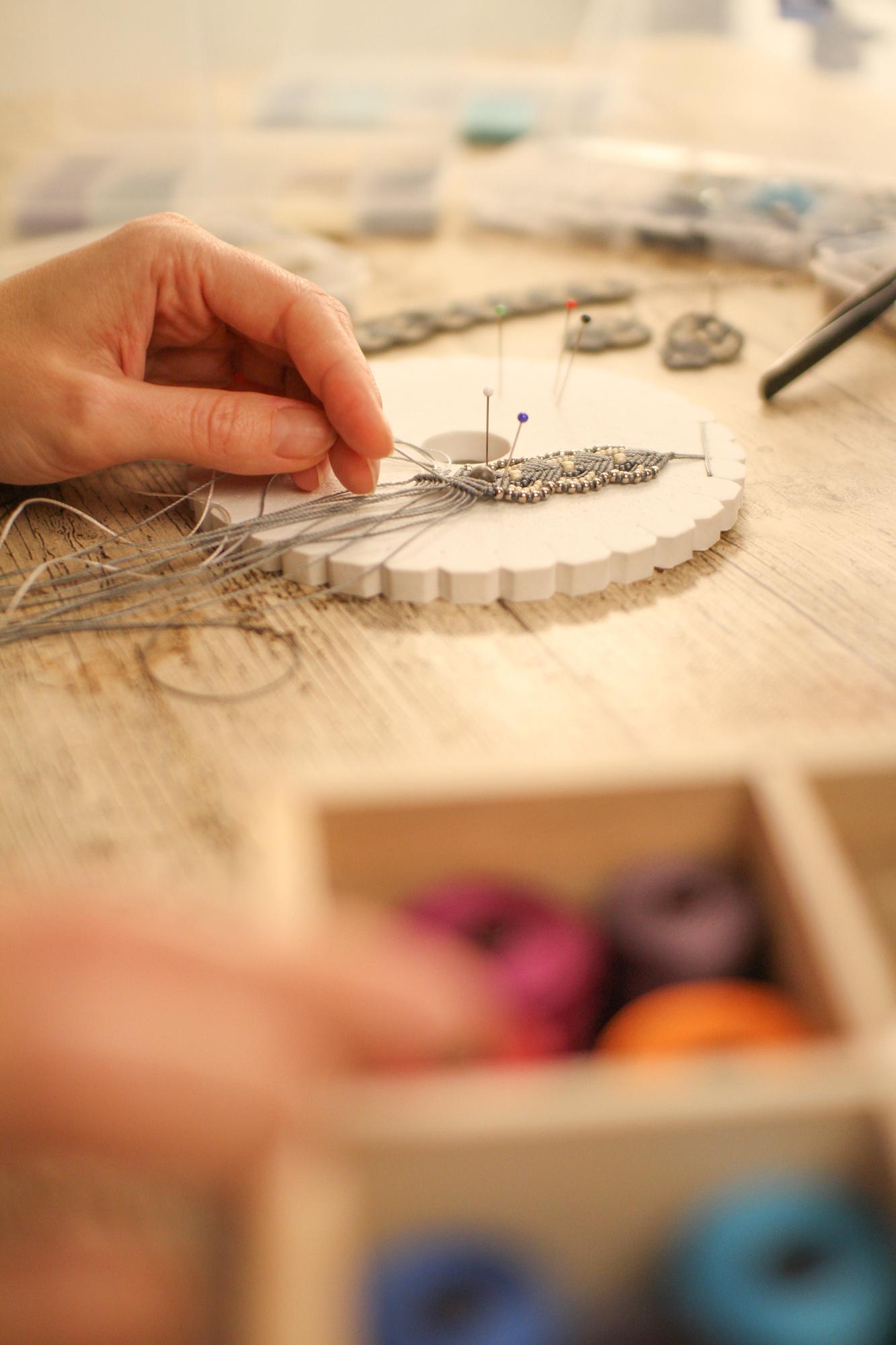 artisan hand threading needle in studio